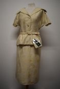 A 1950s unworn Peter Barron two piece suit in cream, comprising skirt with kick pleat to back and