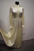 A late 1940s/ early 1950s cream wedding dress, having full length sleeves, gathered waist and
