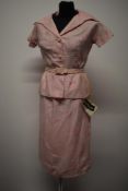 A 1950s unworn Peter Barron two piece suit in pink, comprising skirt with kick pleat to back and