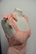 A pink crepe georgette 1930s bias cut nightdress, having bow fastenings to shoulders, pleated