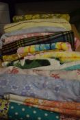 A box full of vintage and retro bedding, towels, a table cloth, a travel rug and similar.