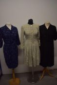 Three 1950s day dresses, comprising; navy blue patterned dress, black textured crepe dress and