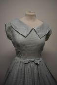 A pale blue 1950s day dress with metallic silver thread running througout, having back metal zip,