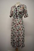 A 1940s brightly patterned linen day dress, with sailor collar, contrasting buttons with loops to