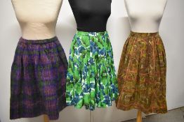 Two 1950s skirts, one of green cotton with floral pattern and tiered skirt, the other abstract