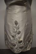 A 1960s cream dress, having floral padded appliqué decoration, high neckline with bow to nape.