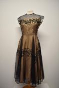 A 1950s 'Helen Berry original' gown, having peach taffeta base layer, high neckline with button to