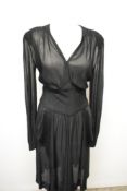 A late 1930s/early 40s semi sheer black day dress, having peplum detail to pointed dropped