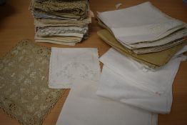 A large collection of antique and vintage napkins, tray cloths and mats, including damask and