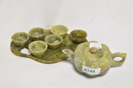 A Chinese carved and varigated green stone miniature tea set, comprising pumpkin shaped teapot,