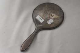 A Hallmarked silver and bevelled glass hand mirror, having embossed floral pattern to reverse.