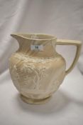 A 20th Century relief moulded ceramic jug, of Classical style, stamped to the underside '