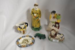 Two 19th Century glazed pottery figural ornaments, a Staffordshire style miniature recumbent lion, a