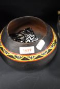 An African clay bowl, with hand painted decoration on black ground and three beaded necklaces and