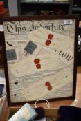 A framed and glazed collage incorporating parts of vintage indentures, postage marks and seals.