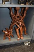An African hardwood link carved table base and a similar stand.