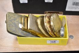 A collection of vintage compacts and a cigarette case.
