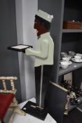 A novelty painted figural dumbwaiter stand, measuring 93cm tall