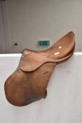 A vintage leather saddle, studs marked Gibson Saddlers, New Market