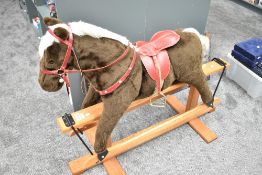 A modern Pegasus plush Rocking Horse having leather saddle on traditional wooden swing action