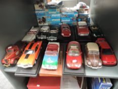 Twelve 1:18 and similar scale diecasts including Maisto, Burago and similar, most on plastic stands