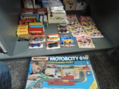 A shelf of 1980's and later Matchbox diecasts including Motorcity G10 Container Port, Thunderbirds