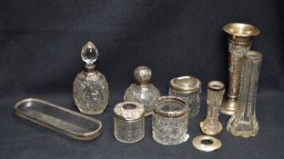 An Edwardian silver spill vase, of tapering cylindrical form with embossed foliate scroll decoration
