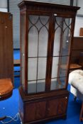 A reproduction Regency narrow display cabinet