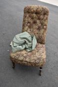 A Victorian nursing or boudoir chair having turned mahogany legs and stuffed seat and back with