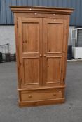 A rustic pine wardrobe on drawer base