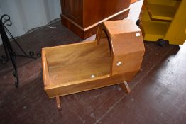 A vintage stained frame rocking cot of small proportions