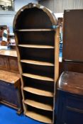 A vintage narrow bookshelf having waterfall style base
