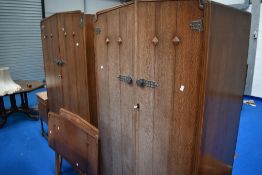 An early to mid 20th Century oak bedroom suite comprising two wardrobes, dressing table and pair