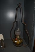 A vintage brass stable lamp with bracket, having glass chimney.