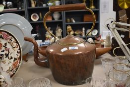 A large vintage copper and brass kettle.