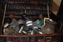 A wicker basket containing vintage nautical accessories, including a Tuph-Fittings winch, and