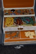 A selection of decorative costume jewellery contained within a mid-20th Century faux leather