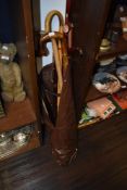 A group of mixed walking sticks, golfing umbrella, flask stick (with internal glass flask' etc