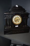 A Victorian black marble mantel clock of architectural structure, with etched detailing and bevelled