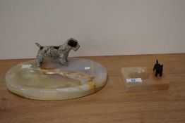An Art Deco and cold painted Scottie dog ashtray with onyx base, together with a larger version