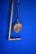 A traditional copper warming pan and a brass fender
