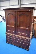 An 18th Century and later oak linen press/wardrobe with faux bottom and drawers, with just two short