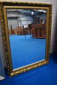 A modern overmantel or wall mirror having gilt effect frame
