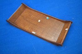 A golden oak Arts and Crafts tray having sleigh form handles, in the Arthur Simpson Handicrafts