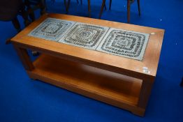 A vintage teak coffee table having studio pottery type design to top and castors to base