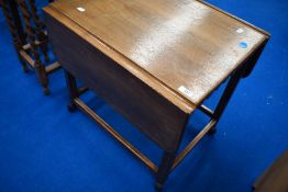 A cintage oak tea trolley table having drop leaves
