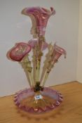 A 19th century epergne, having cranberry tinged trumpets with scalloped edges, and similar fluted