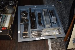 An assortment of stainless steel cutlery, many still new in packaging.