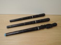 An African wood with metal bladed Tribal Dagger with circular stick scabbard, grip carved in a