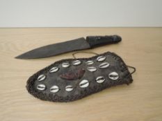 A possible West African Dagger having Shell and wooden mask decorated leather scabbard, wooden